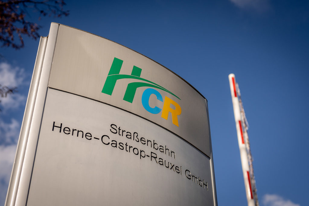 Informationsstele am Eingang des HCR-Betriebshofes mit HCR-Logo und Unternehmensnamen