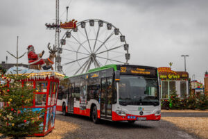 HCR-Bus auf dem Gelände des Crange Weihnachtszaubers. Im Hintergrund ist das Riesenrad zu sehen.
