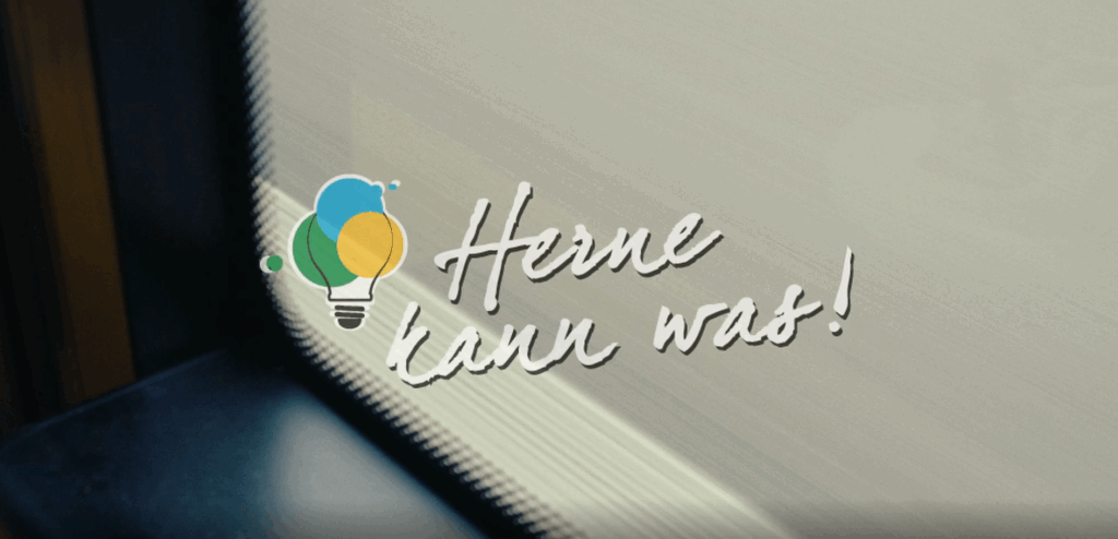 Screenshot aus dem HCR-Video mit dem Logo von „Herne kann was!“ und einer Straße im Hintergrund