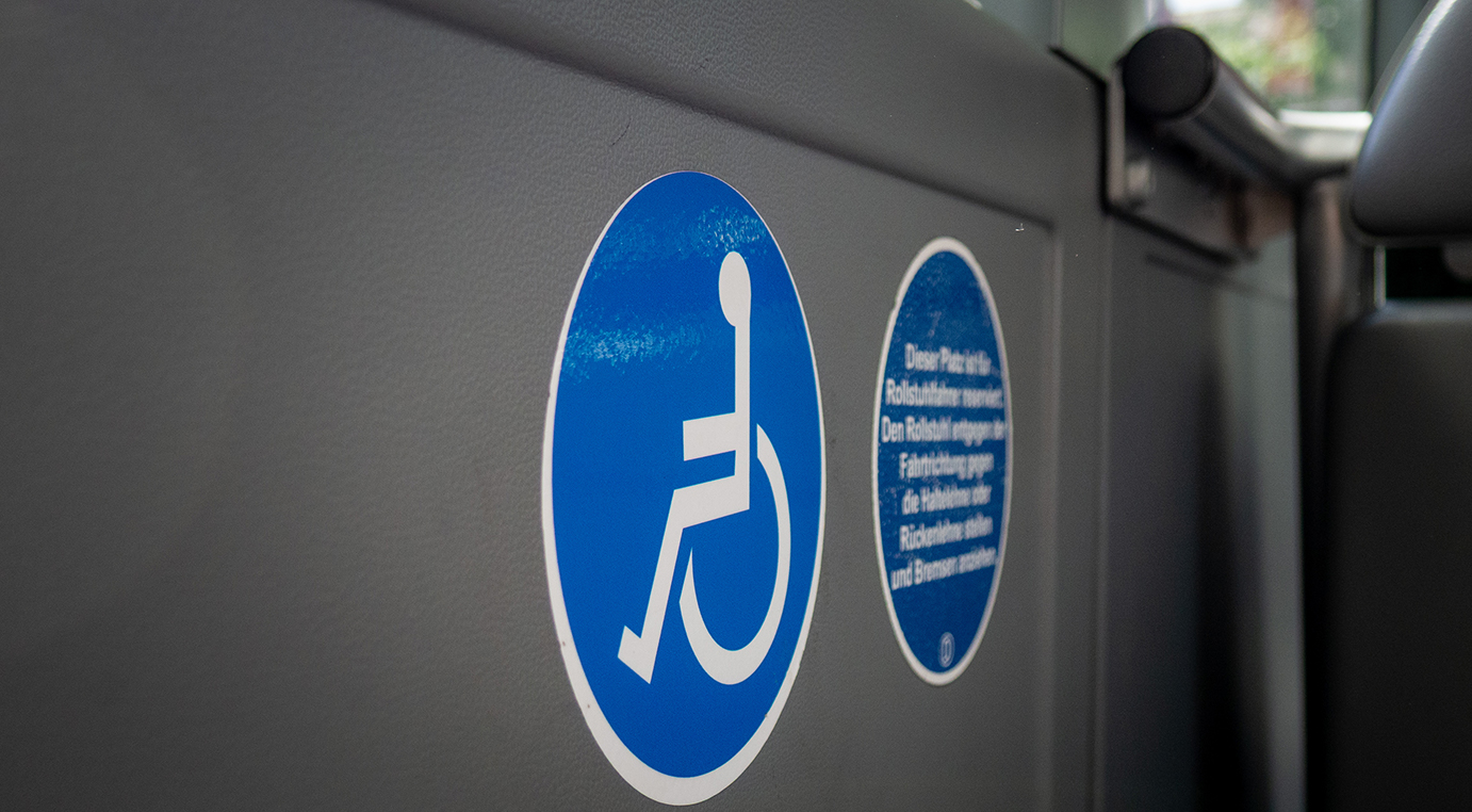 Aufkleber im Bus, die auf den Platz für Rollstuhlfahrende hinweisen