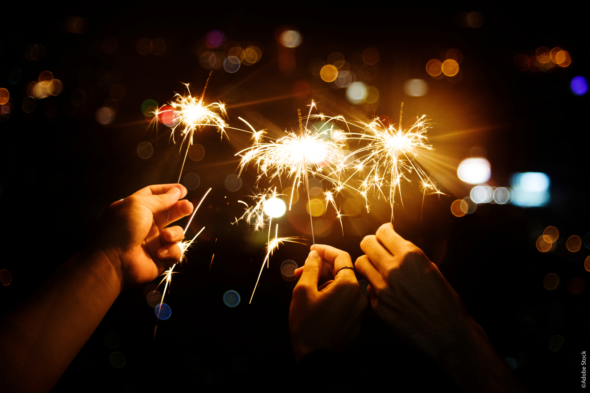 Mehrere Hände halten Wunderkerzen.