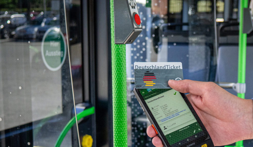 Prüfung eines DeutschlandTickets im Bus mit Prüfgerät